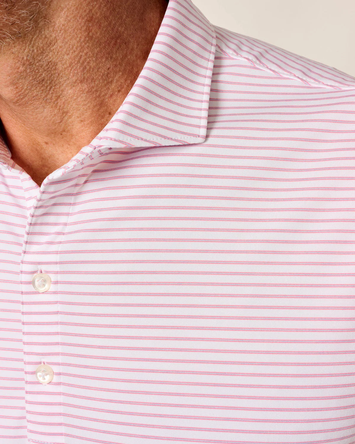 Close-up of a person wearing a pink and white striped shirt.