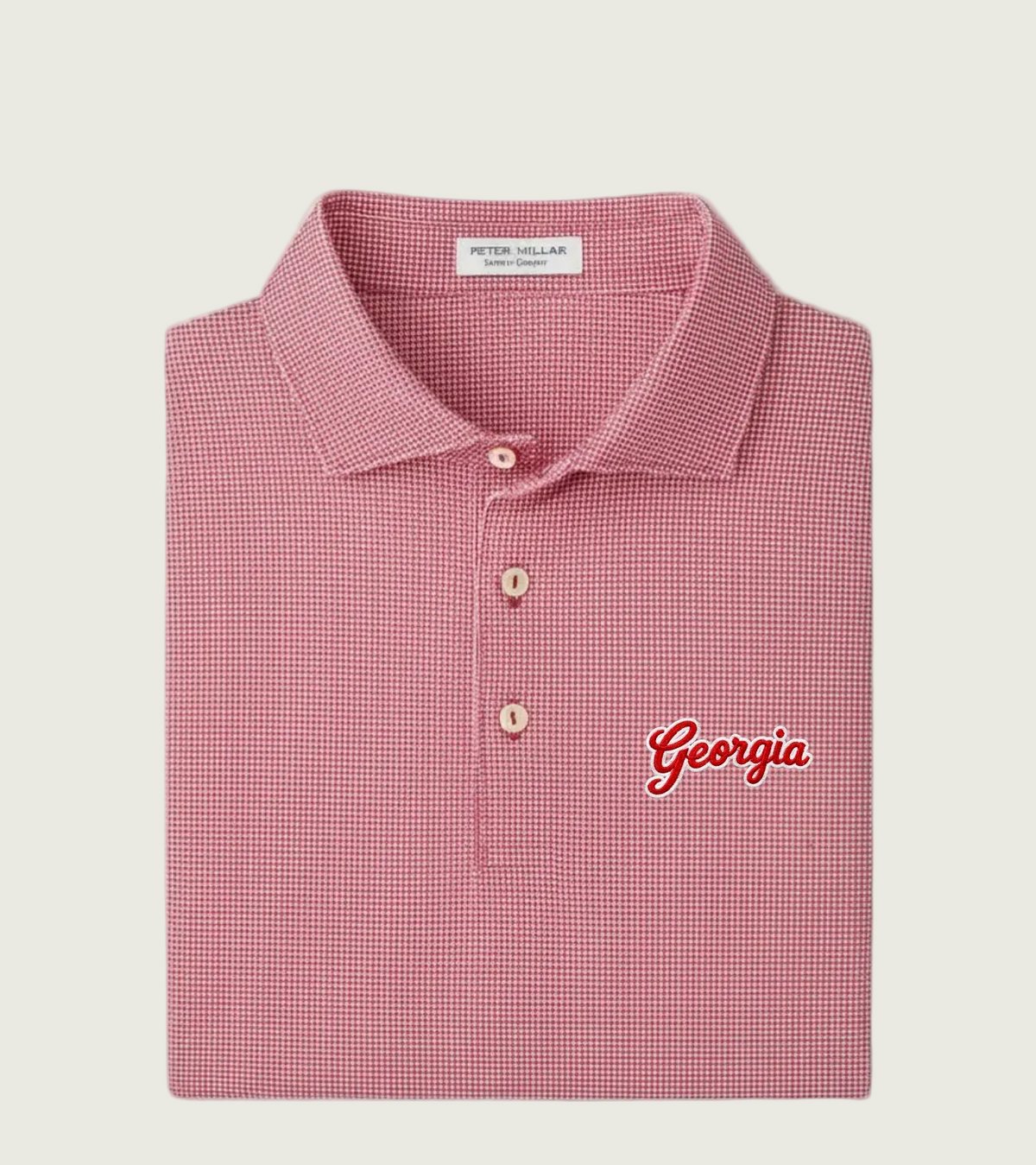 A folded Peter Millar short-sleeve polo shirt in a red and white micro-check pattern, featuring a three-button placket and 'Georgia' embroidered in red script on the left chest.