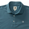 Close up of pique polo shirt with three off white buttons in color Aegean Blue, similar to a teal.