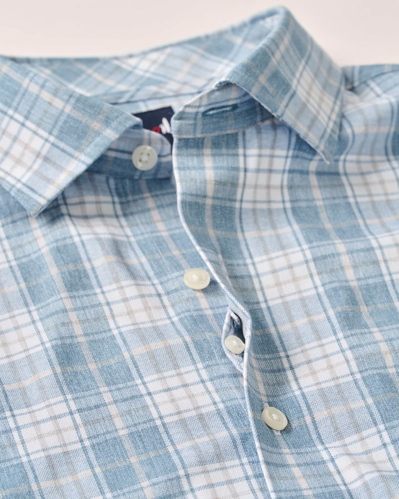 Close-up of a blue and white plaid shirt with buttons.
