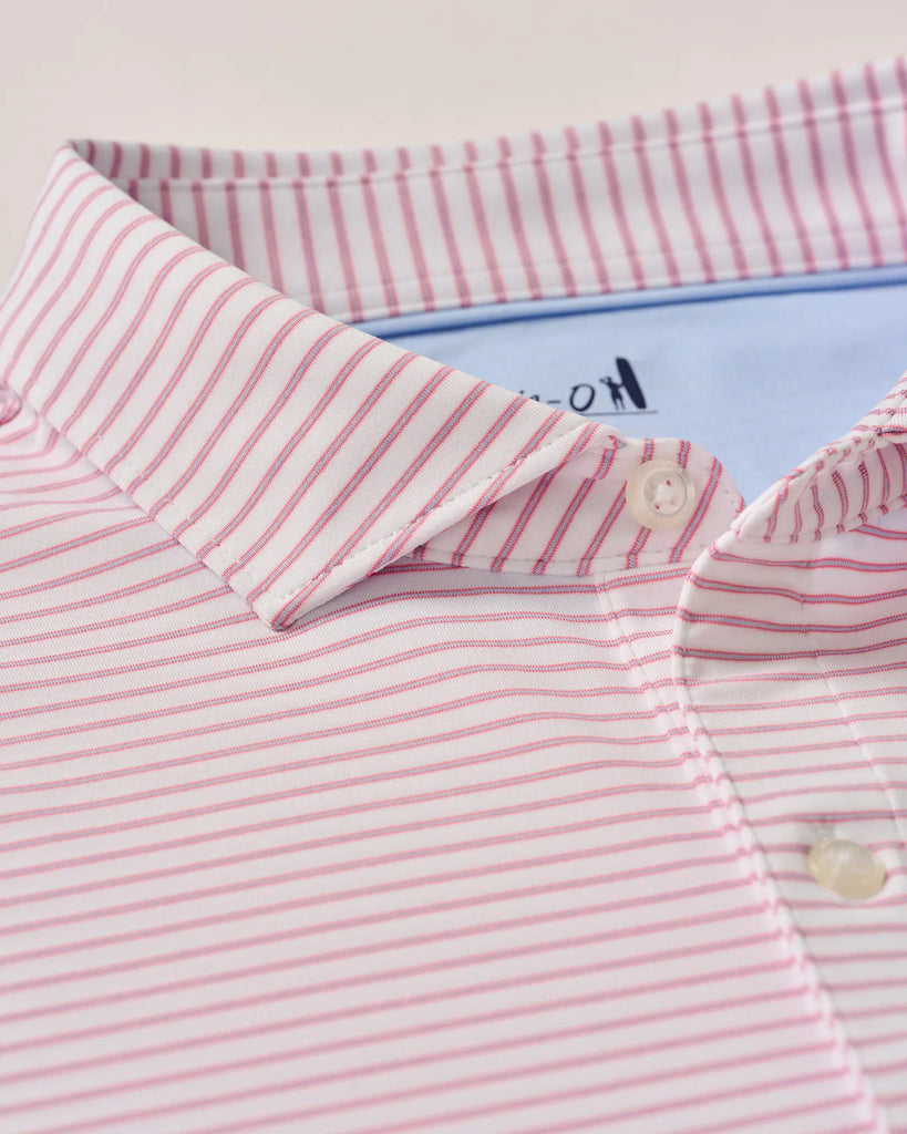 Close-up of a pink and white striped shirt with a brand logo on a light background