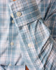 Close-up of a blue and white plaid shirt with rolled-up sleeve