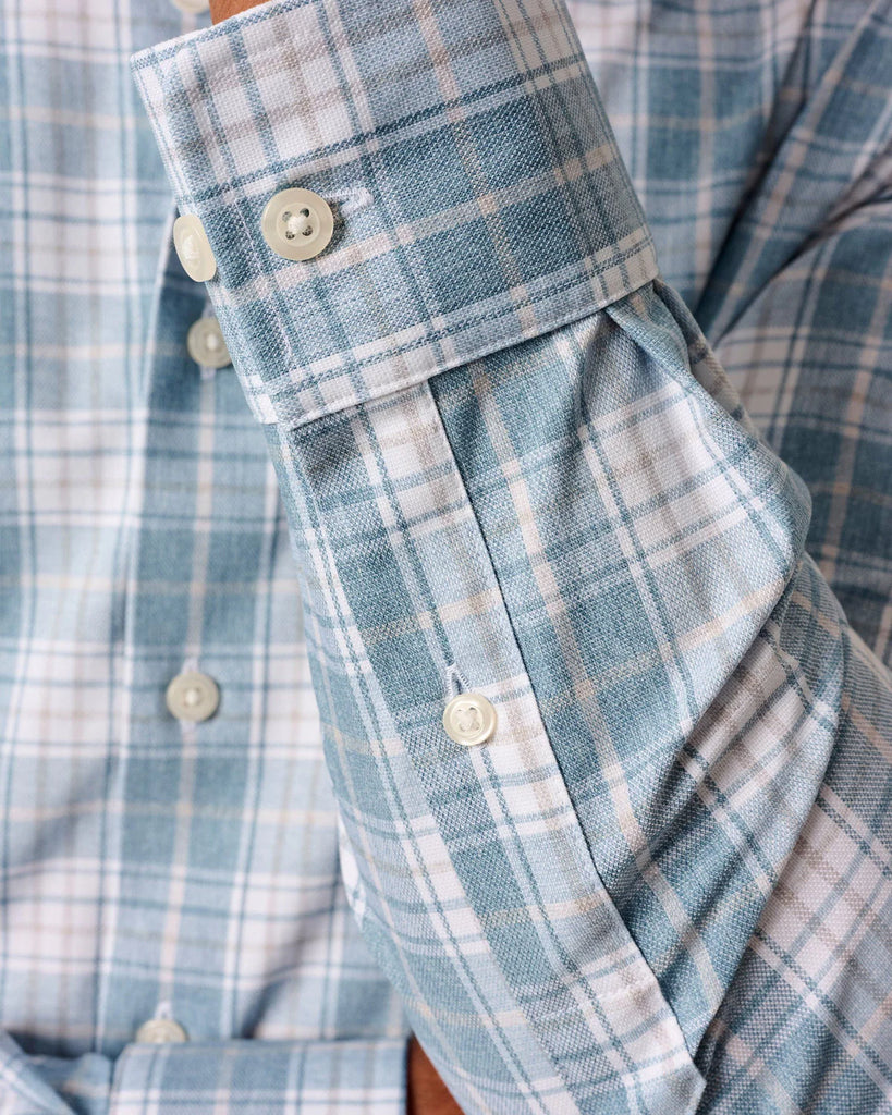 Close-up of a blue and white plaid shirt with rolled-up sleeve