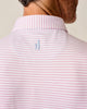 Close-up of a person wearing a pink and white striped polo shirt with a small blue Johnnie-O logo on the nape of the neck.