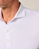 Close-up of a white patterned shirt with a collar and buttons on a neutral background