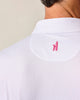 Close-up of a white textured shirt with a pink logo on the collar against a beige background