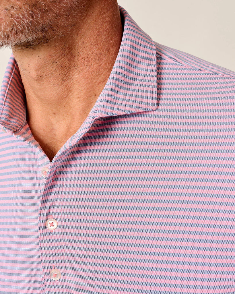Close-up of a man wearing a pink and blue striped shirt.
