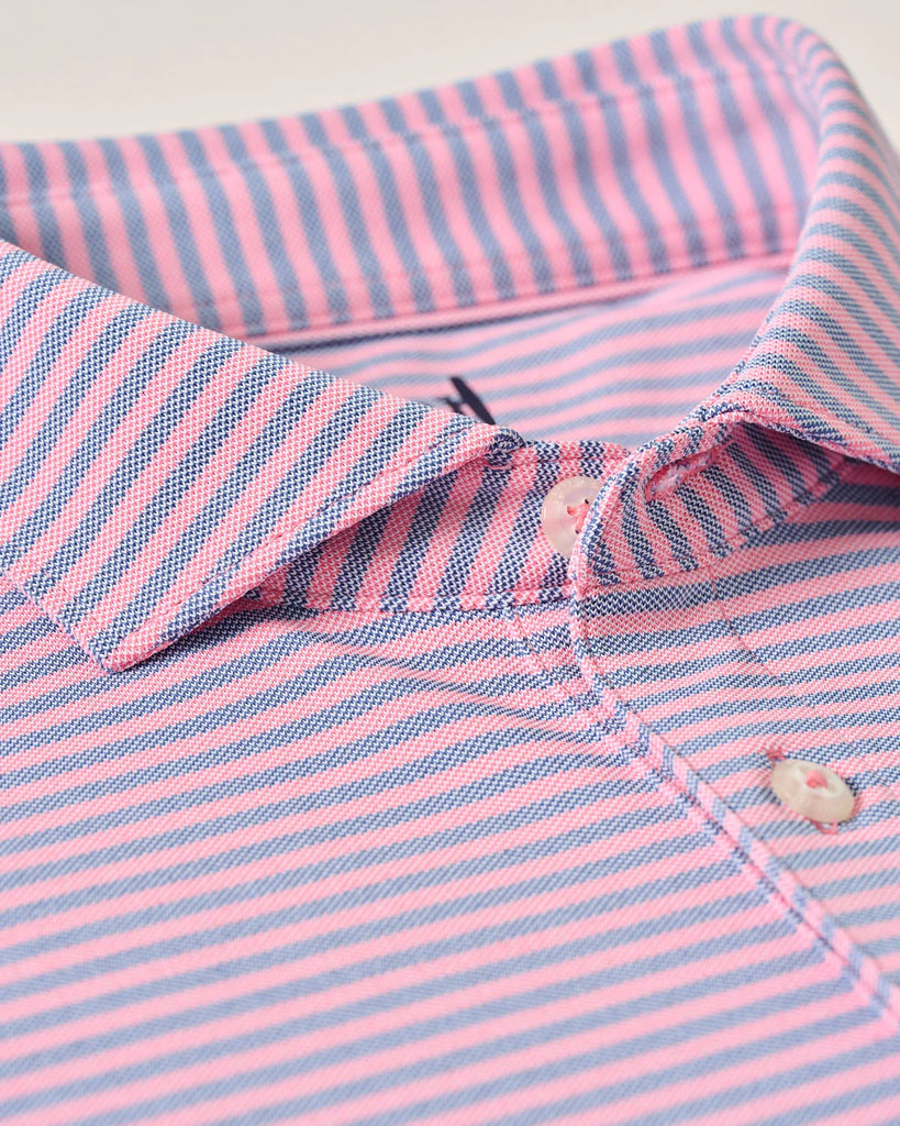 Close-up of a pink and blue striped shirt with a button detail.