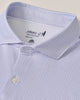Close-up of a light purple patterned shirt with a brand label on a beige background