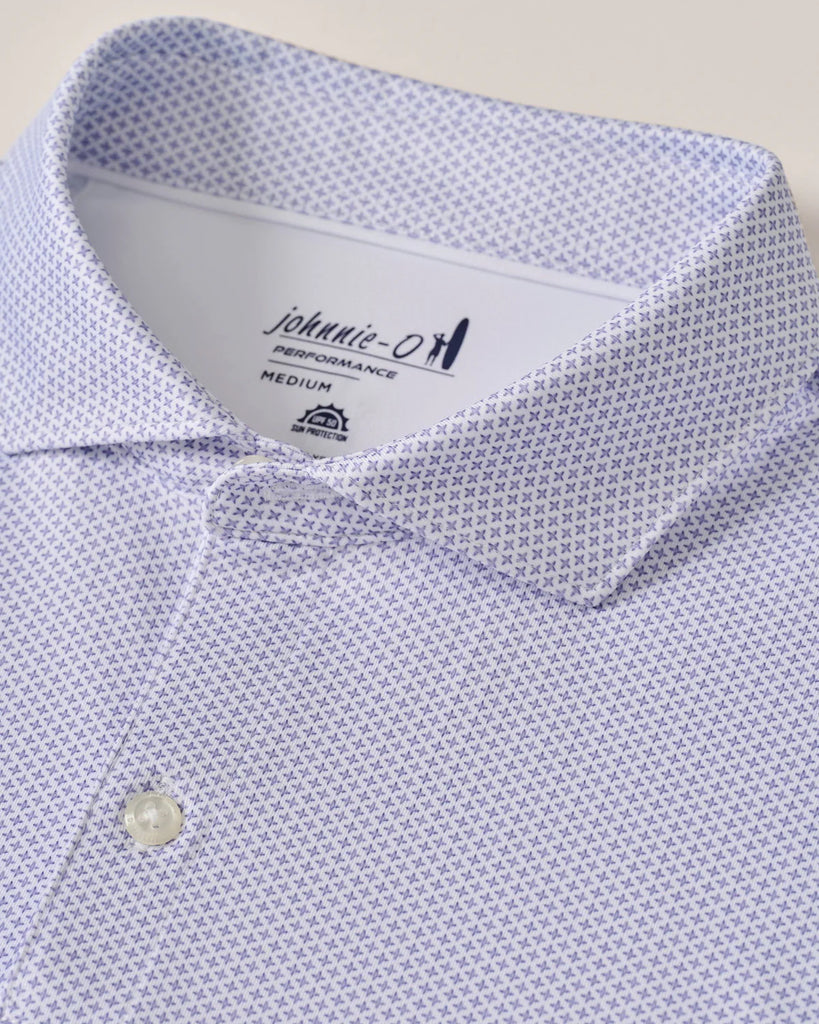 Close-up of a light purple patterned shirt with a brand label on a beige background