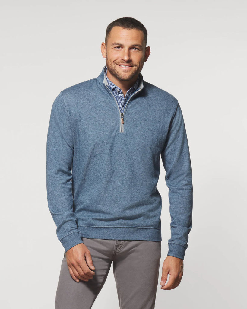 Man wearing a blue quarter-zip pullover on a light gray background