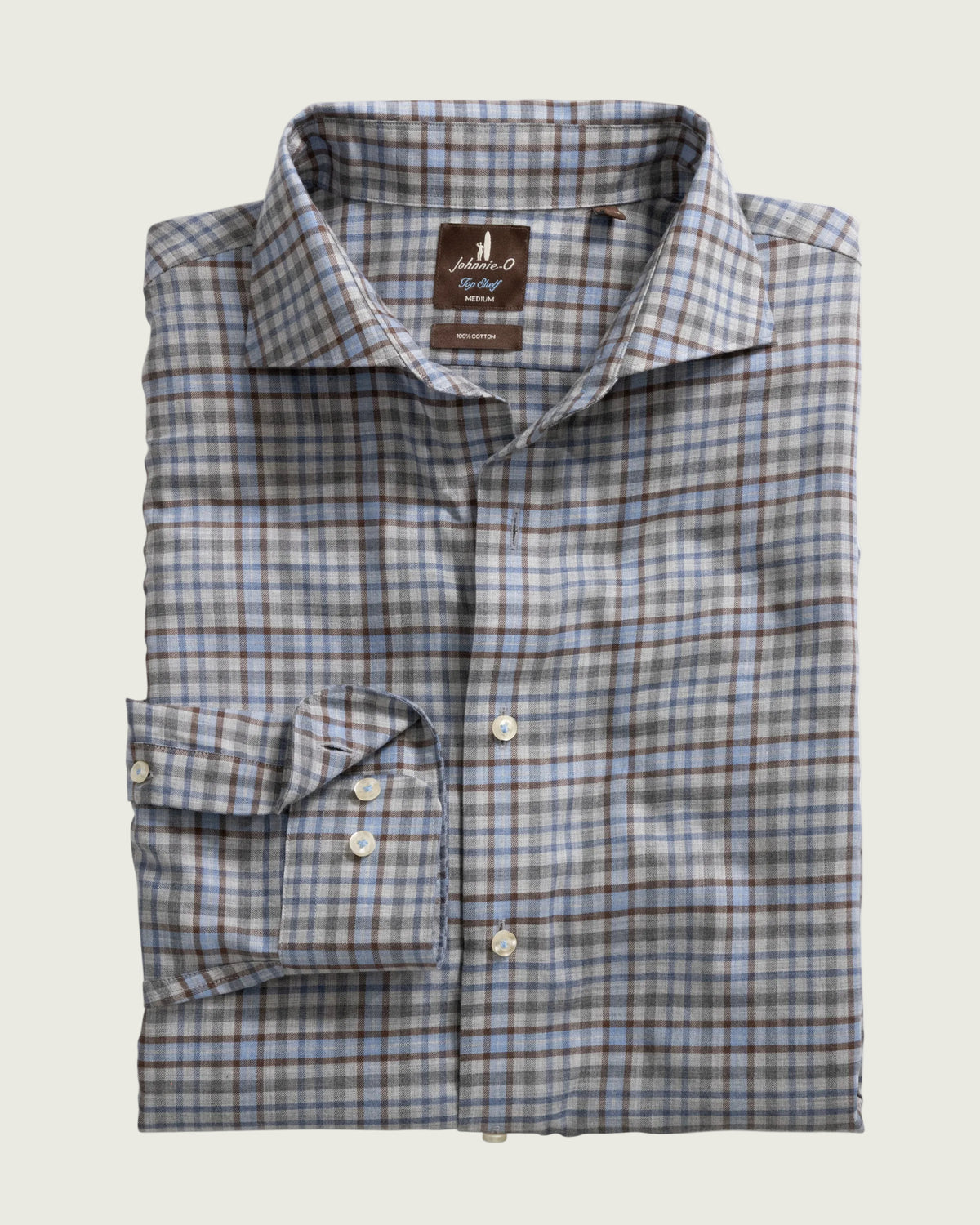 Folded plaid shirt with a brand label on a white background