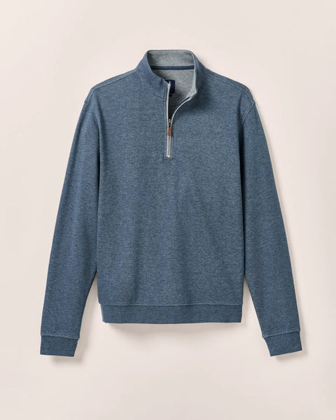 Blue quarter-zip pullover on a beige background
