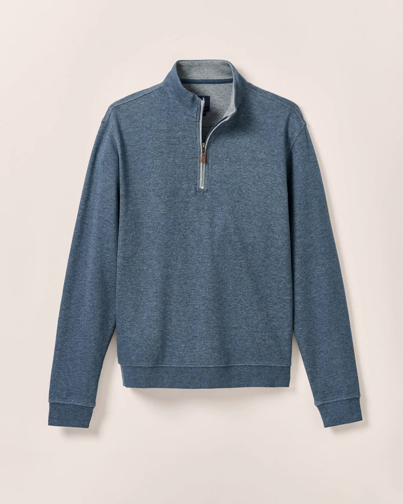 Blue quarter-zip pullover on a beige background