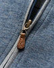 Close-up of a blue pullover with a brown zipper pull.