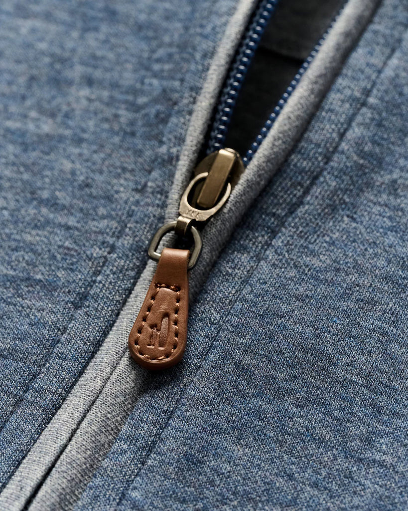 Close-up of a blue pullover with a brown zipper pull.